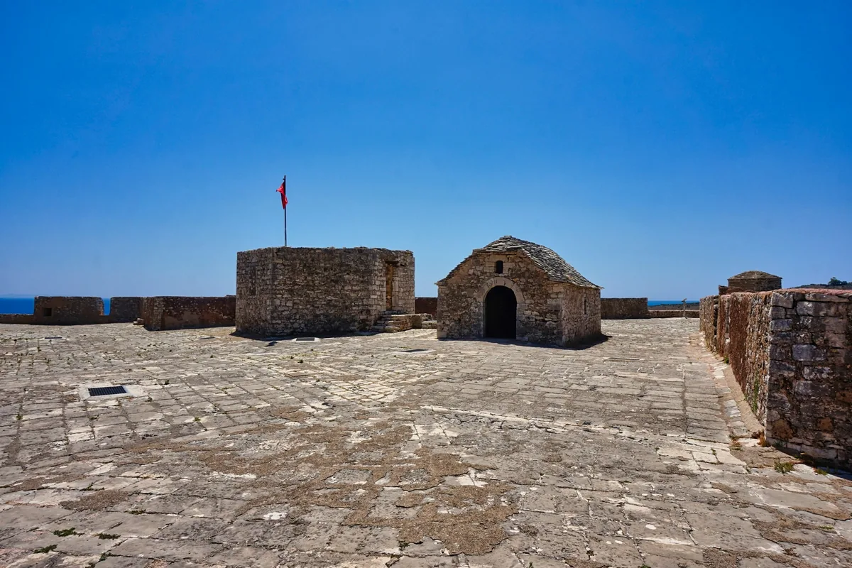 Stone walls and courtyard of Porto Palermo castle above the sea
