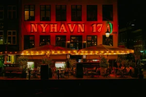 Glowing outdoor terraces on the Nyhavn waterfront in Copenhagen at night