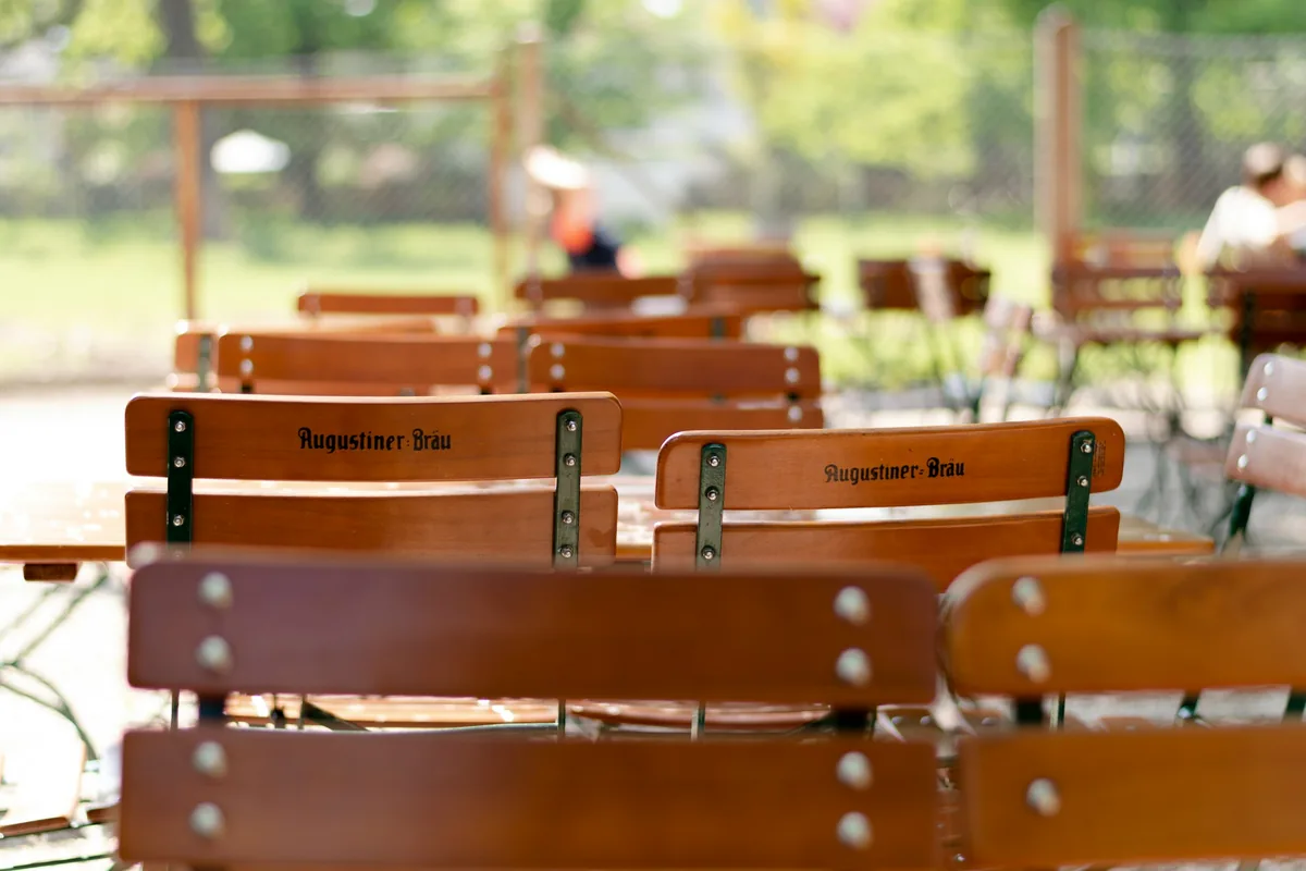 Wooden beer garden chairs and tables at the Hirschgarten in Munich