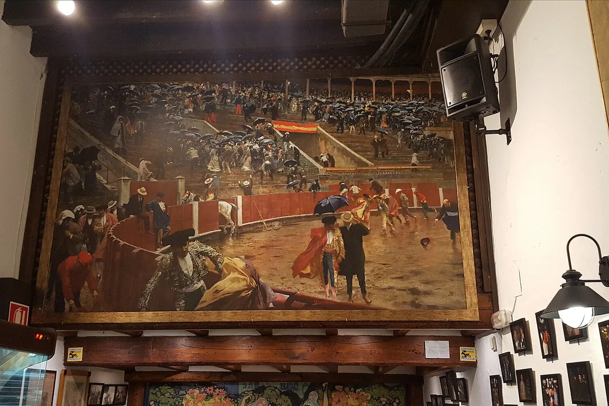 Interior of El Pimpi bodega in Malaga with a bullfighting mural and bottles
