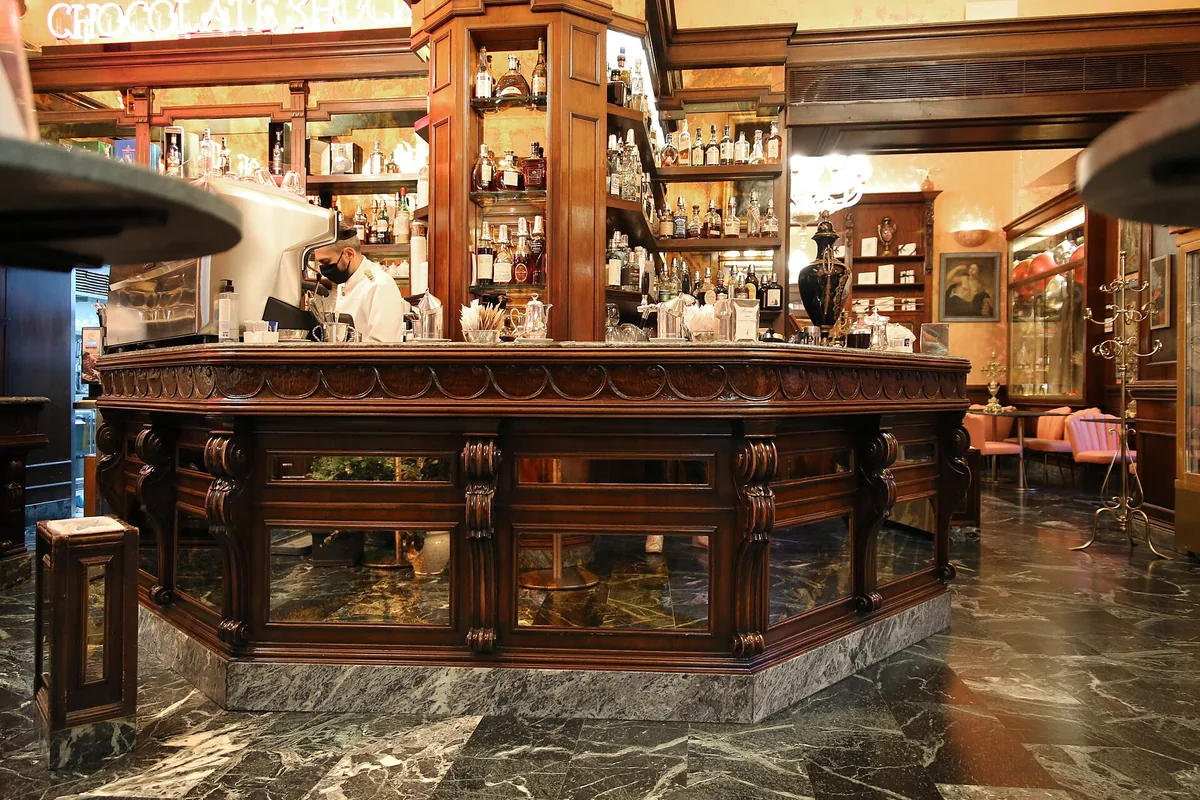 The wooden bar counter and pastry cases inside Caffè Rivoire in Florence