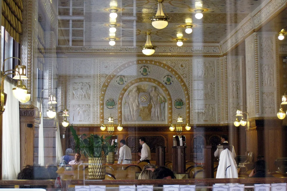The ceramic-tiled interior of Café Imperial, Prague, seen through its window
