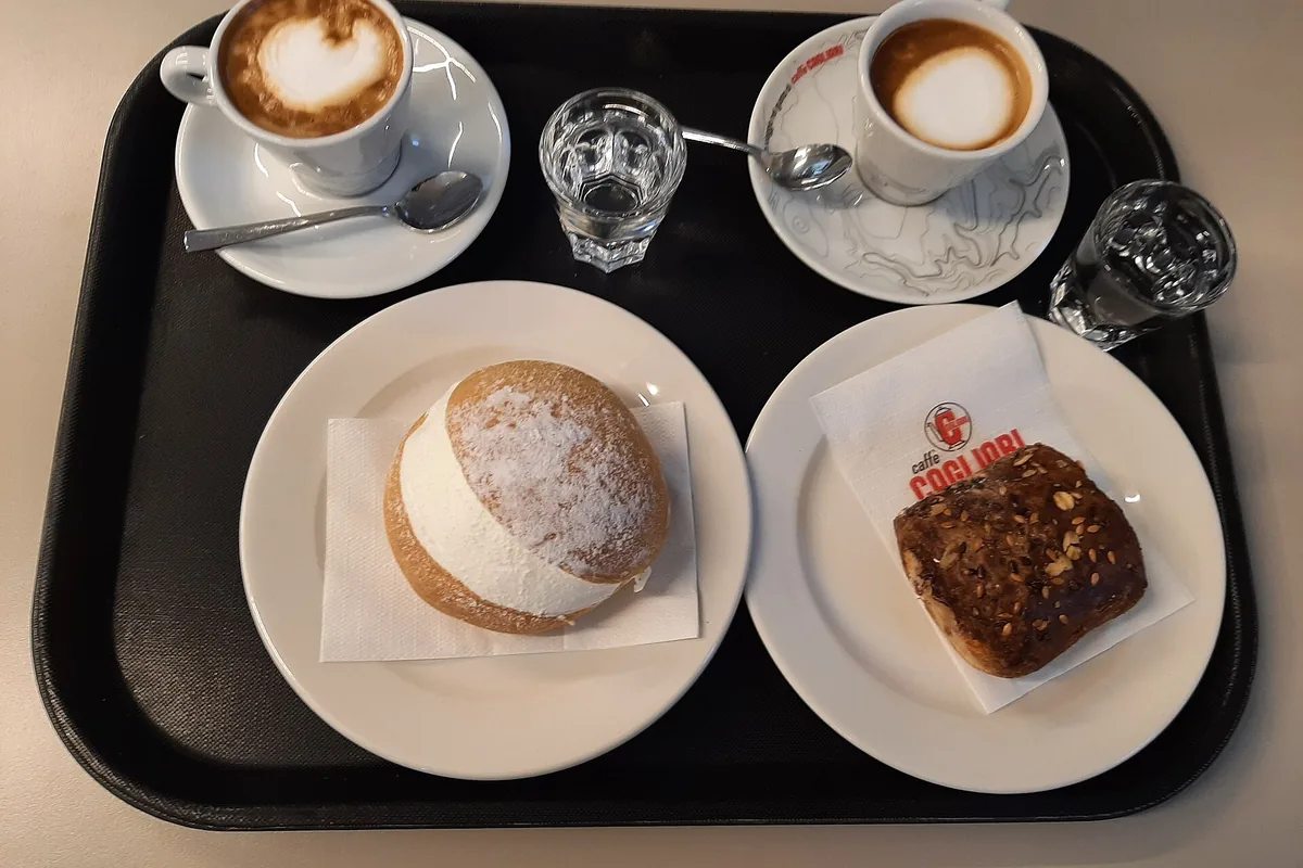 A cream-filled maritozzo served with coffee