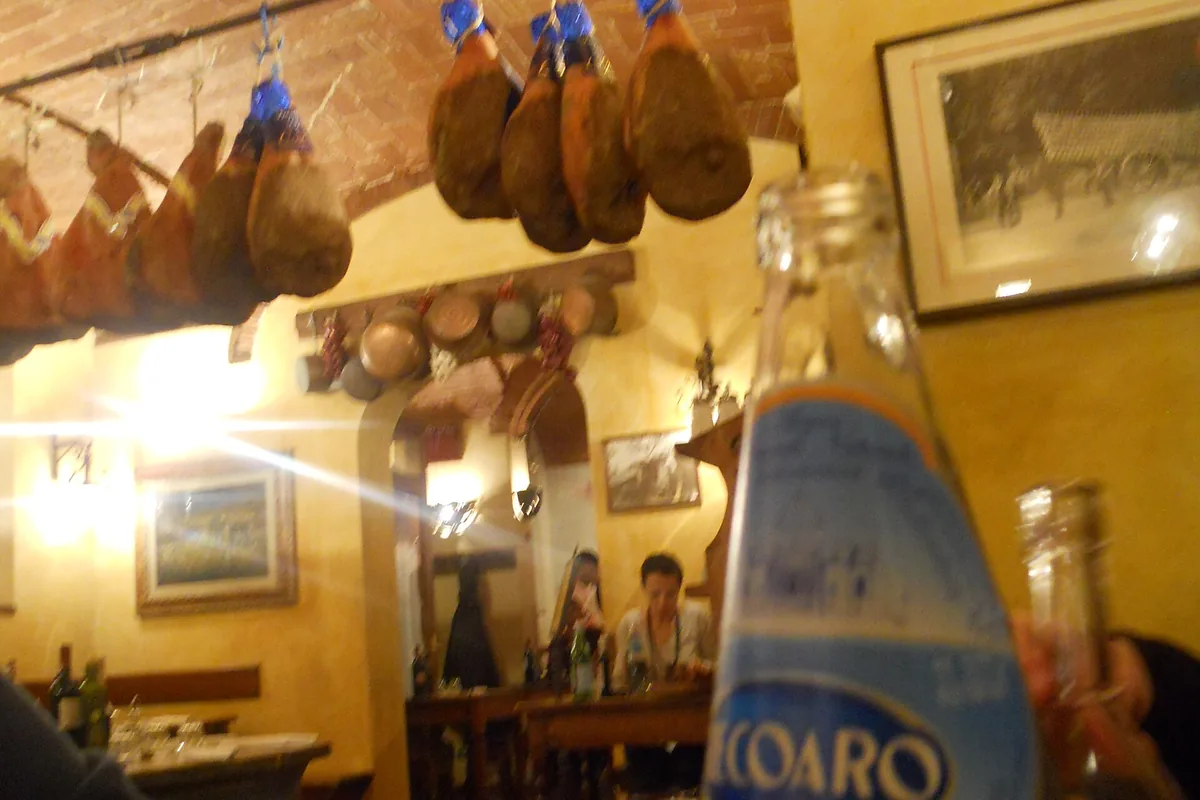 Dining room of Il Latini in Florence with hams hanging from the vaulted ceiling