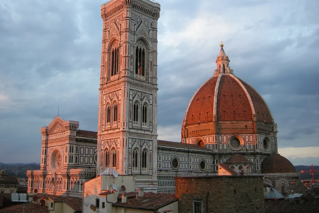 Giotto's bell tower and the Duomo at sunset, seen from a rooftop terrace in central Florence