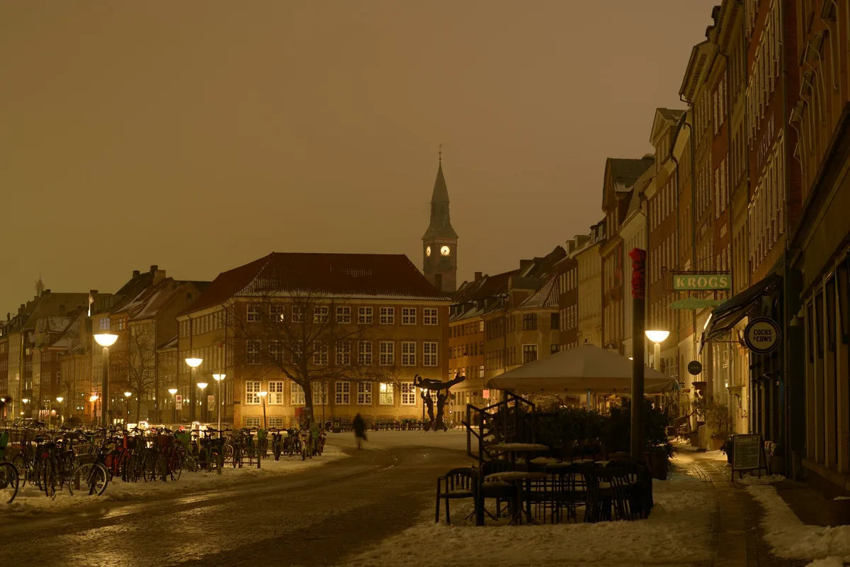 Gammel Strand in central Copenhagen on a snowy evening, with a church spire behind