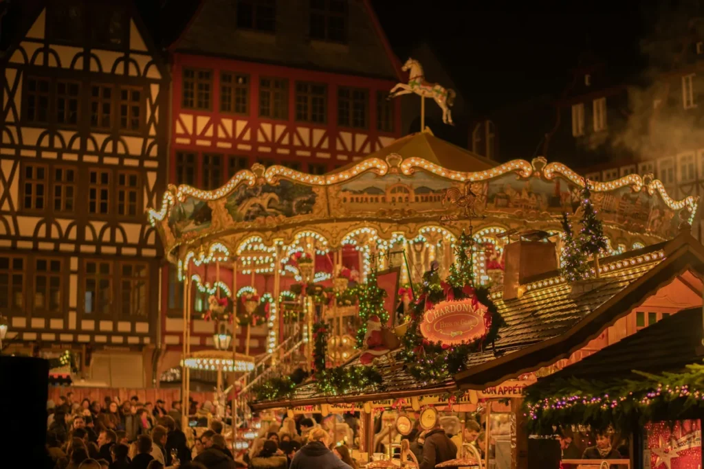 Wooden Christmas market stalls lit up at night in a European old town square