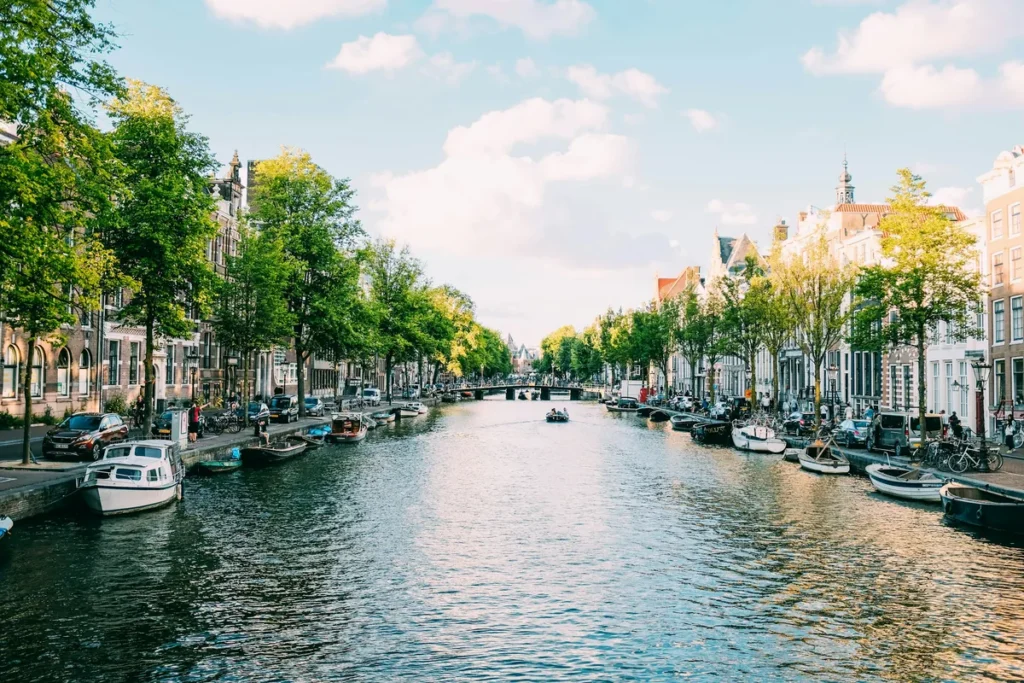 A tree-lined canal with moored boats and canal houses in Amsterdam, the Netherlands