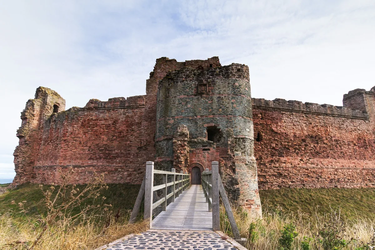 The red sandstone curtain wall and entrance bridge of Tantallon Castle in East Lothian