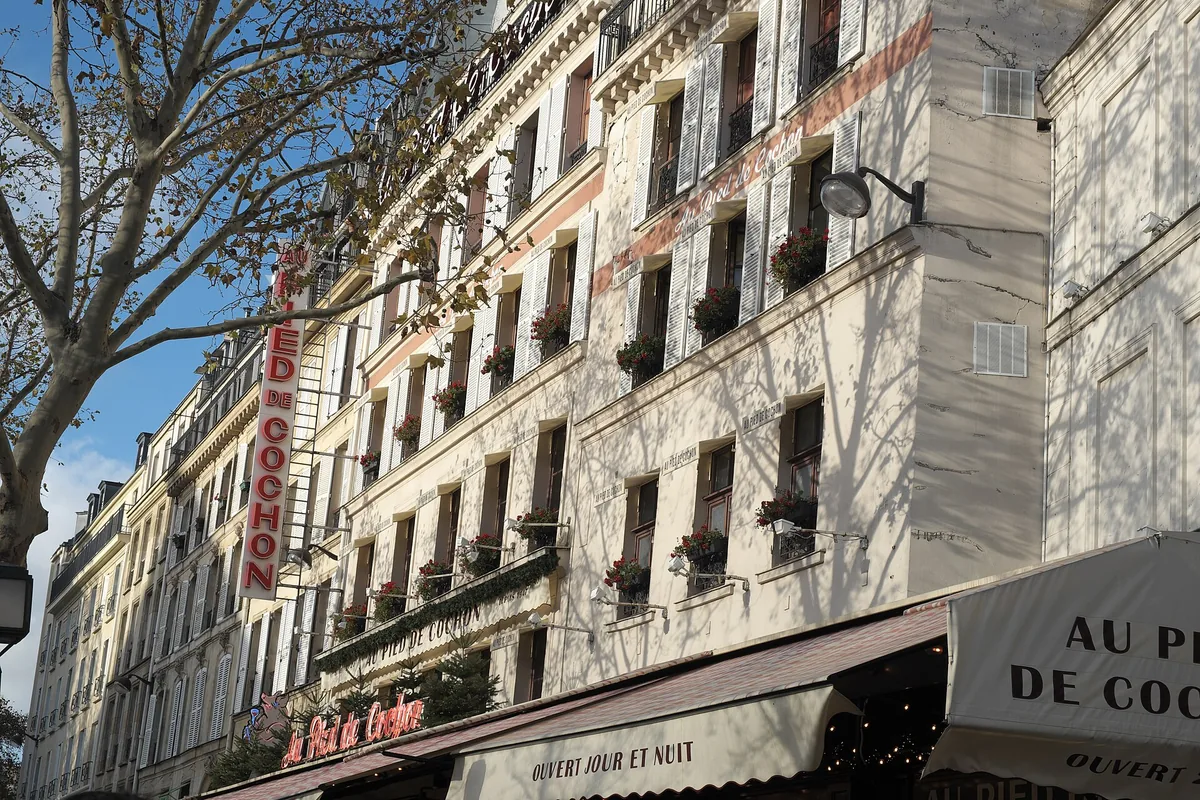 The facade and signs of Au Pied de Cochon brasserie on Rue Coquillière beside Les Halles in Paris