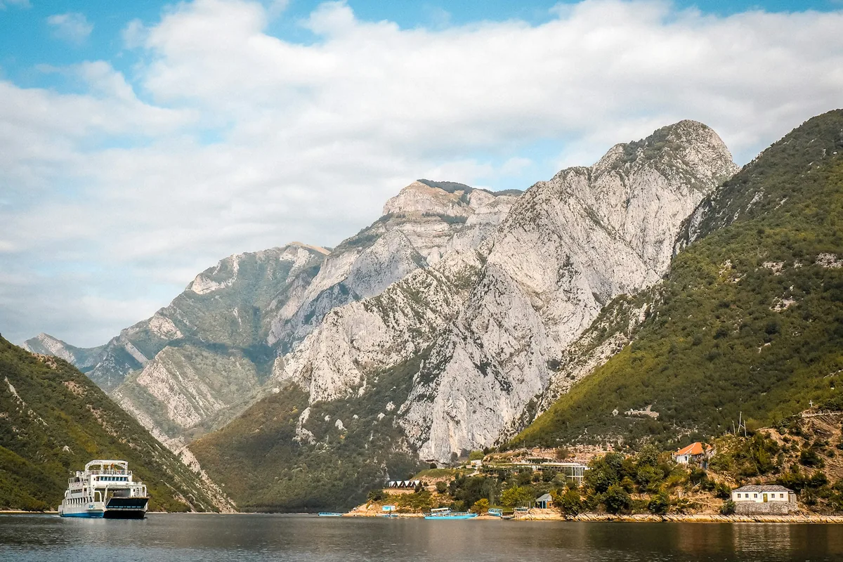 Ferry on Lake Komani between steep limestone mountains