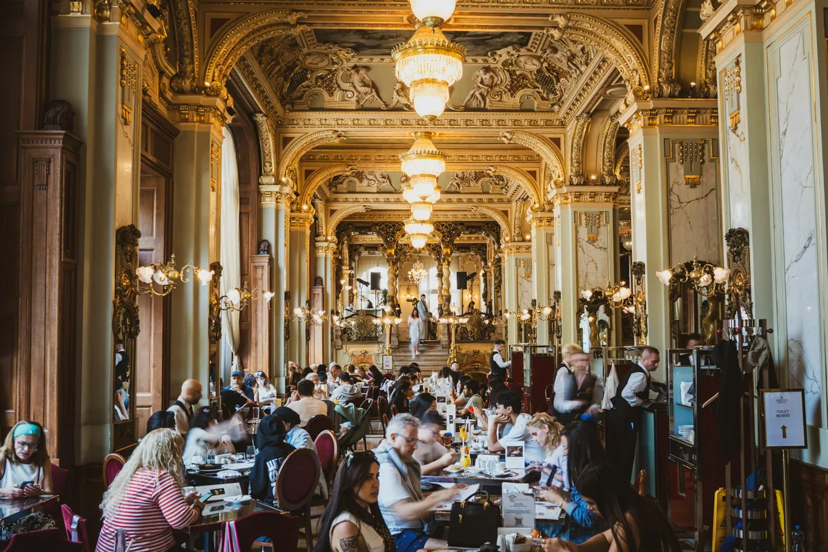 Ornate chandeliers and gilded columns inside the New York Café in Budapest