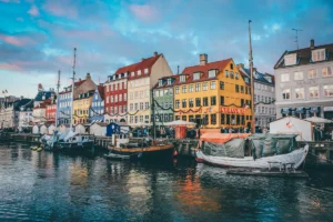 Boats moored along the Nyhavn canal in front of colourful townhouses in Copenhagen