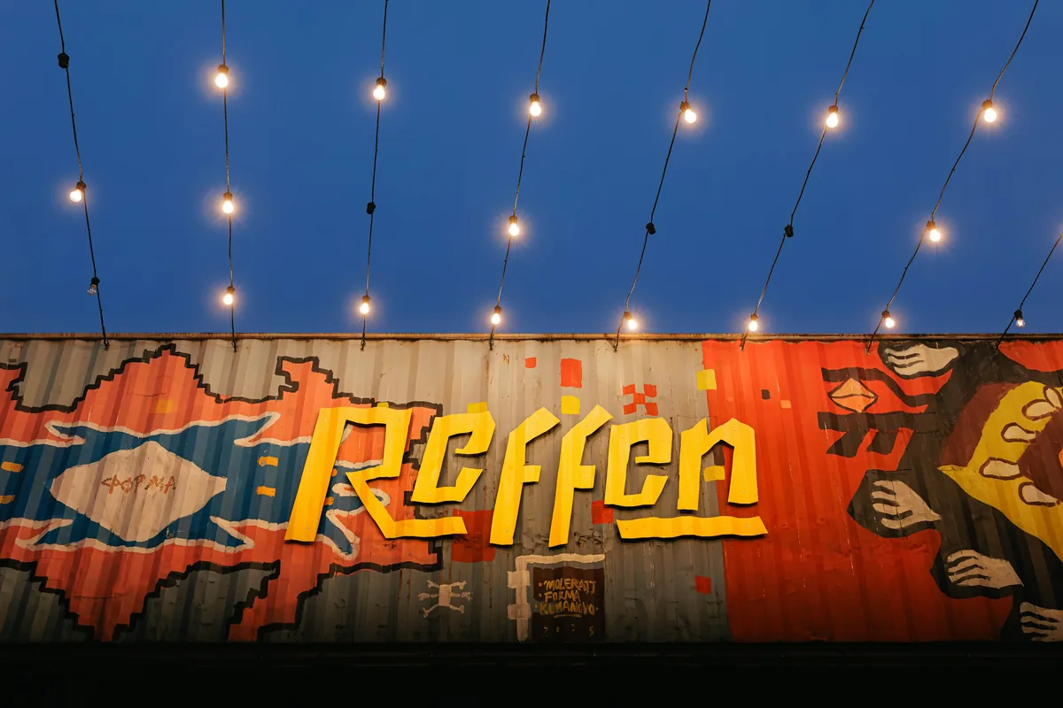Reffen street food market graffiti on a shipping container, with string lights, on Refshaleøen in Copenhagen
