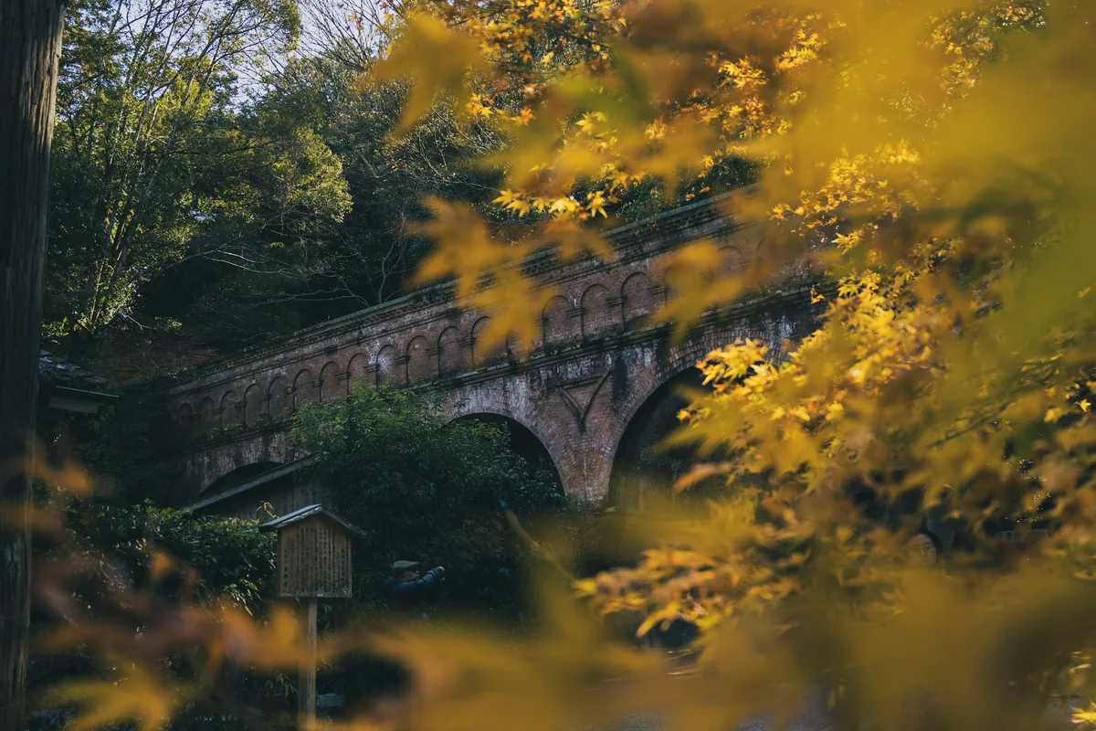 The brick aqueduct arches at Nanzen-ji, Kyoto, seen through autumn leaves