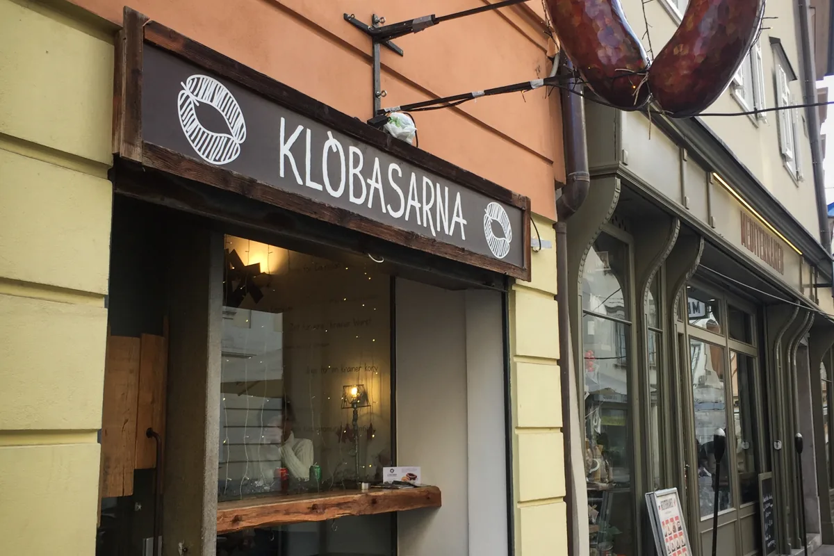 The Klobasarna sausage bar entrance and sign on Ciril-Metodov trg in Ljubljana