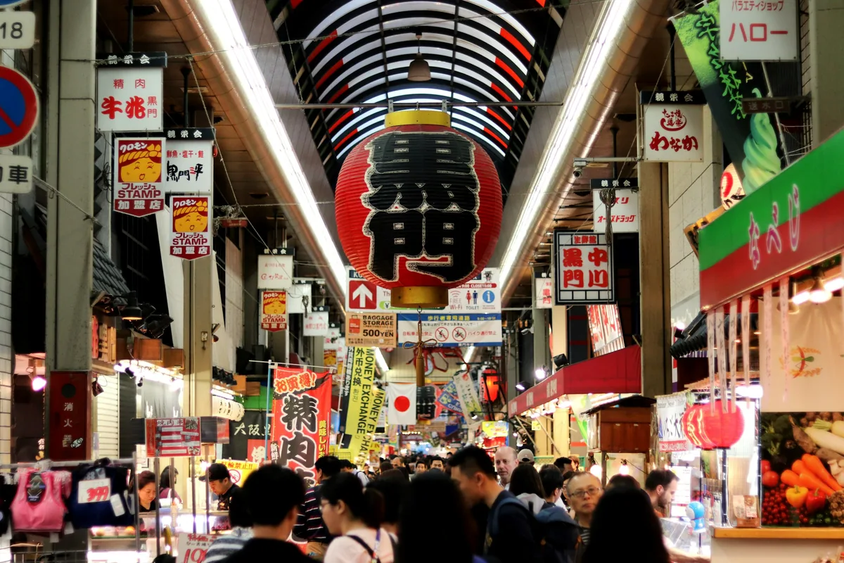 Giant lantern sign and busy stalls inside Kuromon Ichiba Market, Osaka