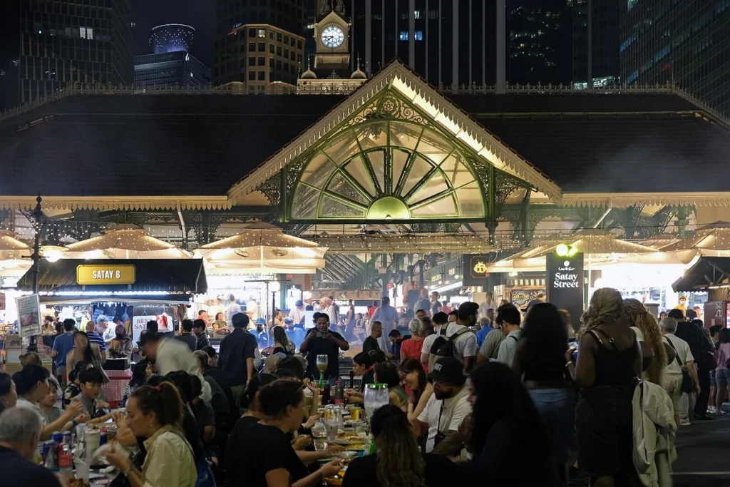Diners at Satay Street beside the Lau Pa Sat market hall in Singapore at night