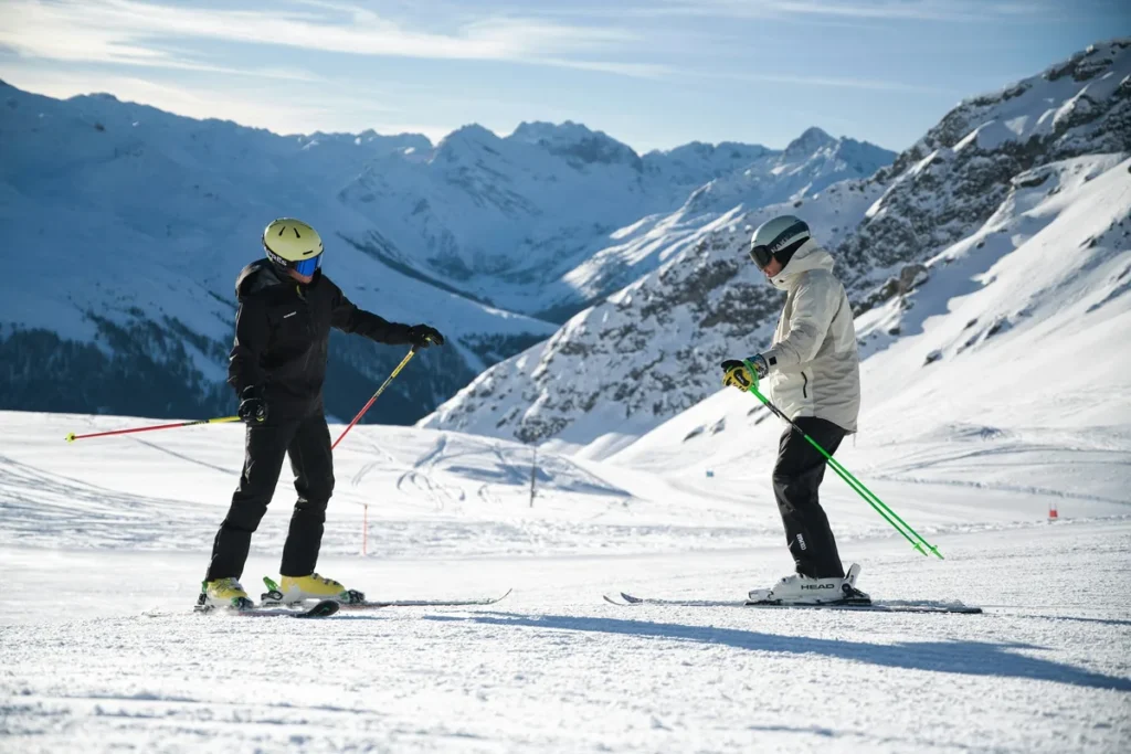 Beginner skiers on a gentle groomed slope in the Alps