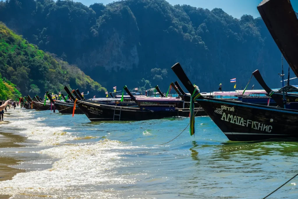 Long-tail boat and limestone cliffs on a Thai island beach