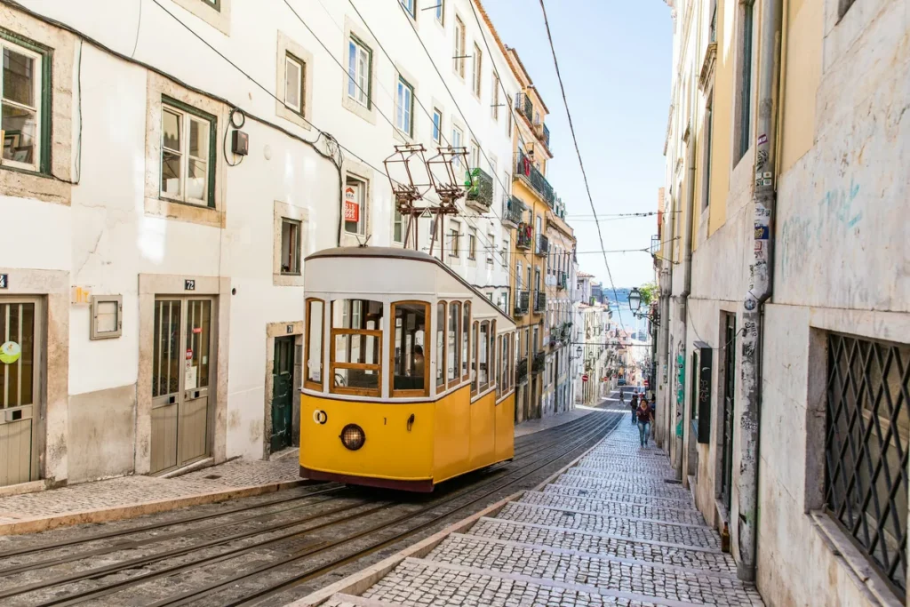 Yellow tram on a steep street in Lisbon's Alfama district