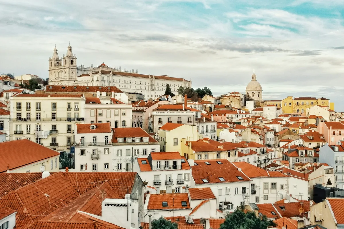 Terracotta rooftops of Alfama and the white towers of São Vicente de Fora in Lisbon