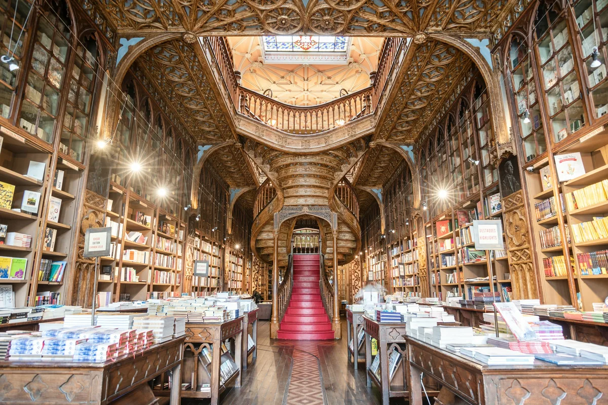 Red curving staircase and carved wood interior of Livraria Lello in Porto