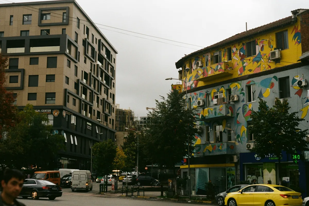 Brightly painted apartment building on a street in Tirana