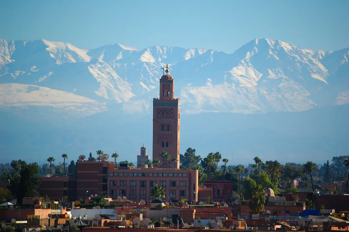 Koutoubia Mosque minaret in Marrakech with the snowy Atlas Mountains behind