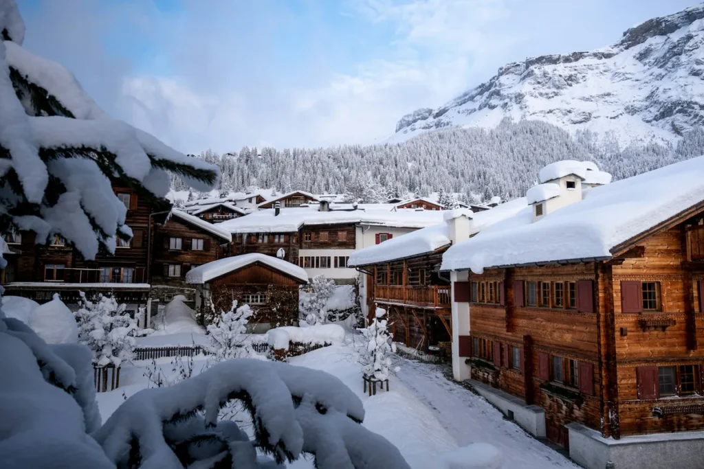 Snow-covered Alpine village with mountains behind